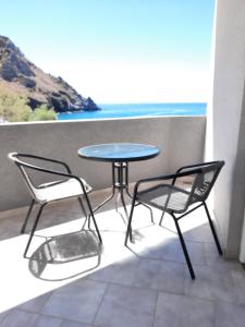 un tavolo e sedie su un balcone con vista sull'oceano di Voula Beach a Lentas