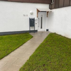 a white building with a white door and a baseball at 1 Zimmer Apartment DG in Eislingen