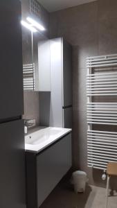 a bathroom with a white sink and a toilet at Valparaiso Koksijde in Koksijde