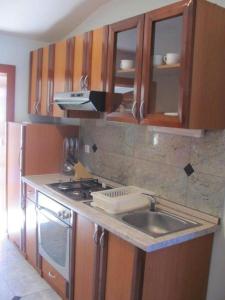 a kitchen with a sink and a stove at Soleil Apartmanok Baska in Baška