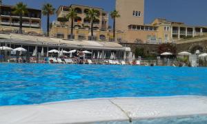 duży basen z niebieską wodą przed hotelem w obiekcie APPARTEMENT CAP ESTEREL CLIMATISE VUE MER w mieście Agay - Saint Raphael +20 zdjęć