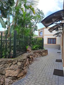 a stone retaining wall next to a fence at Amigos Bed & Breakfast - No loadshedding in Nelspruit