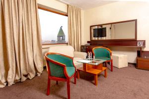 a room with two chairs and a table and a television at Hemus Hotel - Vratza in Vratsa