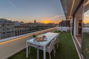 Biały stół i krzesła na balkonie z widokiem w obiekcie Exclusive Penthouse & terrace by ELE Apartments w Maladze
