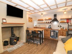 eine Küche und ein Wohnzimmer mit einem Kamin in der Unterkunft 1 Dinas cottages in Caernarfon