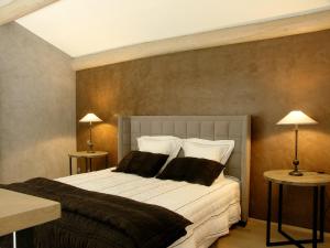 a bedroom with a large bed with two lamps at Château de Cachard in Boffres