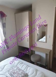 Kirby Misperton的住宿－Flamingo Land - Woodlands W174，一间卧室配有一张床、镜子和椅子