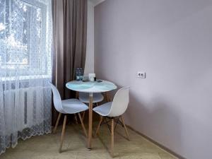 uma mesa e cadeiras num quarto com uma janela em Апартаменти по вул Галицька em Ivano-Frankivsk