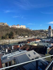 24-7 Apartment Passau في باساو: الإطلالة الأمامية على مدينة يوجد فيها مباني على تلة