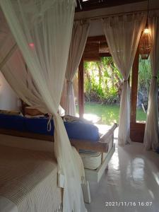 a bedroom with two beds with mosquito netting at Casa Paula in Barra Grande