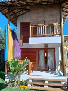 a house with a balcony and a patio at Casa Paula in Barra Grande