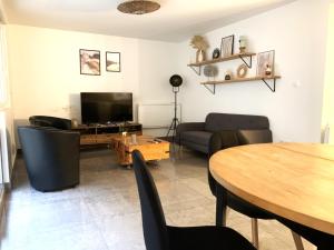a living room with a couch and a table at Appartement tout confort avec terrasse in Reims