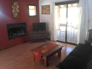 sala de estar con sofá y chimenea en Cabaña Quela en San Martín de los Andes