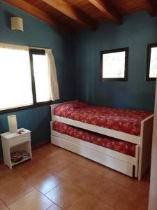 1 dormitorio con 1 cama en la esquina de una habitación en Cabaña Quela en San Martín de los Andes