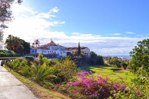 a house on a hill with a green yard at Apartamento Añoreta Malaga 318 in Torre de Benagalbón