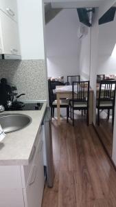 eine Küche mit einem Waschbecken und einem Tisch mit Stühlen in der Unterkunft Casa Dora in Sovata