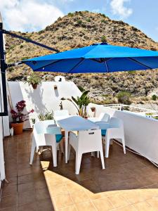 a patio with a table and chairs and an umbrella at AMR Ático Los Atalayones in Mojácar