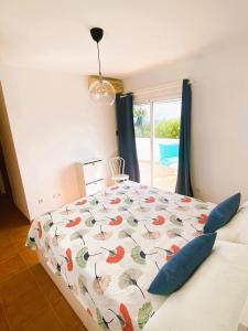 a bedroom with a bed with a colorful comforter at AMR Ático Los Atalayones in Mojácar
