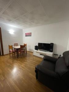 sala de estar con sofá, mesa y sillas en Habitación cómoda en Barcelona, en Esplugues de Llobregat