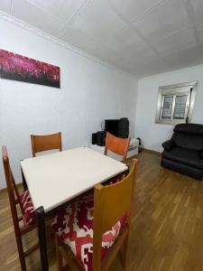 a dining room with a white table and chairs at Habitación cómoda en Barcelona in Esplugues de Llobregat