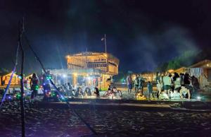 un groupe de personnes sur une plage la nuit dans l'établissement Baraka Camp, à Taba