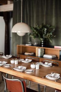 - une table en bois avec des chaises et des assiettes dans l'établissement MÜHLENHOF ROOMS boutique bed & breakfast, à Langenlois
