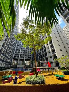 a playground with a tree and chairs in a city at Victoria’s Place in Manila
