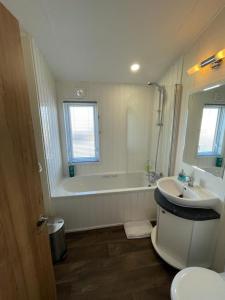 uma casa de banho com uma banheira, um WC e um lavatório. em LA07 Oceanview em Morecambe