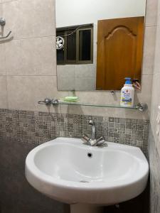 een witte wastafel in een badkamer met een spiegel bij The Penthouse 2BHK in Islamabad