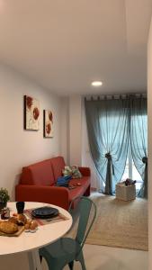 a living room with a red couch and a table at Bnbook Medea Apartments 2 in Fuengirola