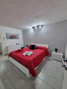 een slaapkamer met een rood bed in een witte kamer bij LamaisondeMaria in Carpinone