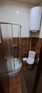 e bagno con servizi igienici e doccia in vetro. di Мотель ОК a Shepetovka