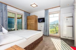 a bedroom with a large bed and a window at Eberharthof in Saalbach-Hinterglemm