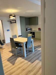 una cucina e una sala da pranzo con tavolo e sedie di Lovely Super Luxury One Bed Apartment 216 a Luton