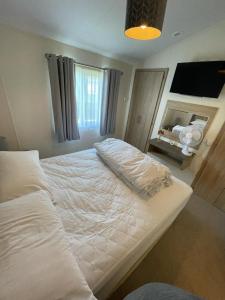 a bedroom with a large white bed with a fireplace at LA07 Oceanview in Morecambe