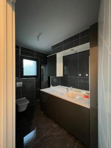 a bathroom with a tub and a sink and a toilet at Soleil de bois d’amont in Bois-dʼAmont