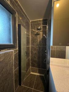 a shower with a glass door in a bathroom at Soleil de bois d’amont in Bois-dʼAmont