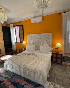 una camera da letto con un grande letto con pareti gialle di Riad New Moon a Marrakech
