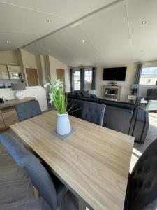 a living room with a wooden table with a vase of flowers at LA07 Oceanview in Morecambe