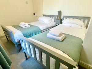 dwa łóżka z ręcznikami na nich w pokoju w obiekcie Park View w mieście York