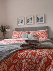 a bedroom with a bed with orange and white bedding at Willow Lodge in Lisnaskea