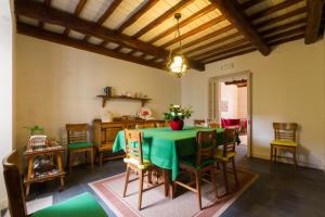 a dining room with a green table and chairs at Casa da Avo in Furnas