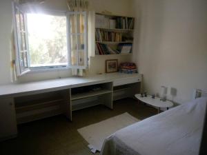 Schlafzimmer mit einem Schreibtisch, einem Fenster und einem Bett in der Unterkunft VILLA KANTOUNI ON THE BEACH in Panormos Kalymnos