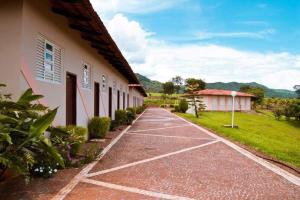 a walkway next to a building with a green yard at Hotel Fazenda Pousada da Serra in Goianésia