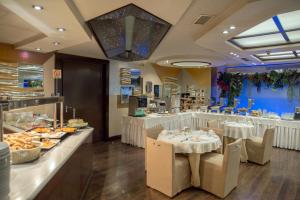 un restaurante con mesas y sillas y un buffet en The Athenian Callirhoe Exclusive Hotel, en Atenas