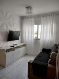 een woonkamer met een bank en een flatscreen-tv bij Ótima Oportunidade - AP Mobiliado in Campina Grande