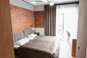 a bedroom with a bed and a brick wall at Miracle Place in Ivano-Frankivsk