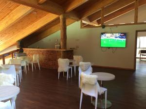 a room with tables and chairs and a flat screen tv at Hotel Robledal in Las Trancas