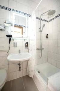 La salle de bains blanche est pourvue d'un lavabo et d'une douche. dans l'établissement Hotel Blüchertal Bacharach, à Bacharach