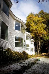 a white house with windows on the side of it at Hotel Robledal in Las Trancas